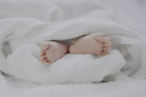 Battaniyeye sarılmış bir bebeğin ayakları